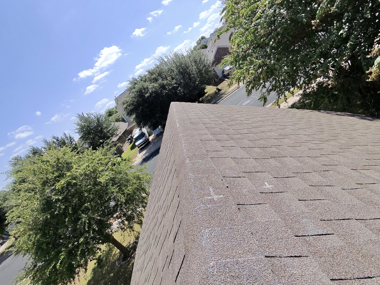 Hip roof edge with chalk circles marking individual hail strikes on the shingles in Leander, TX